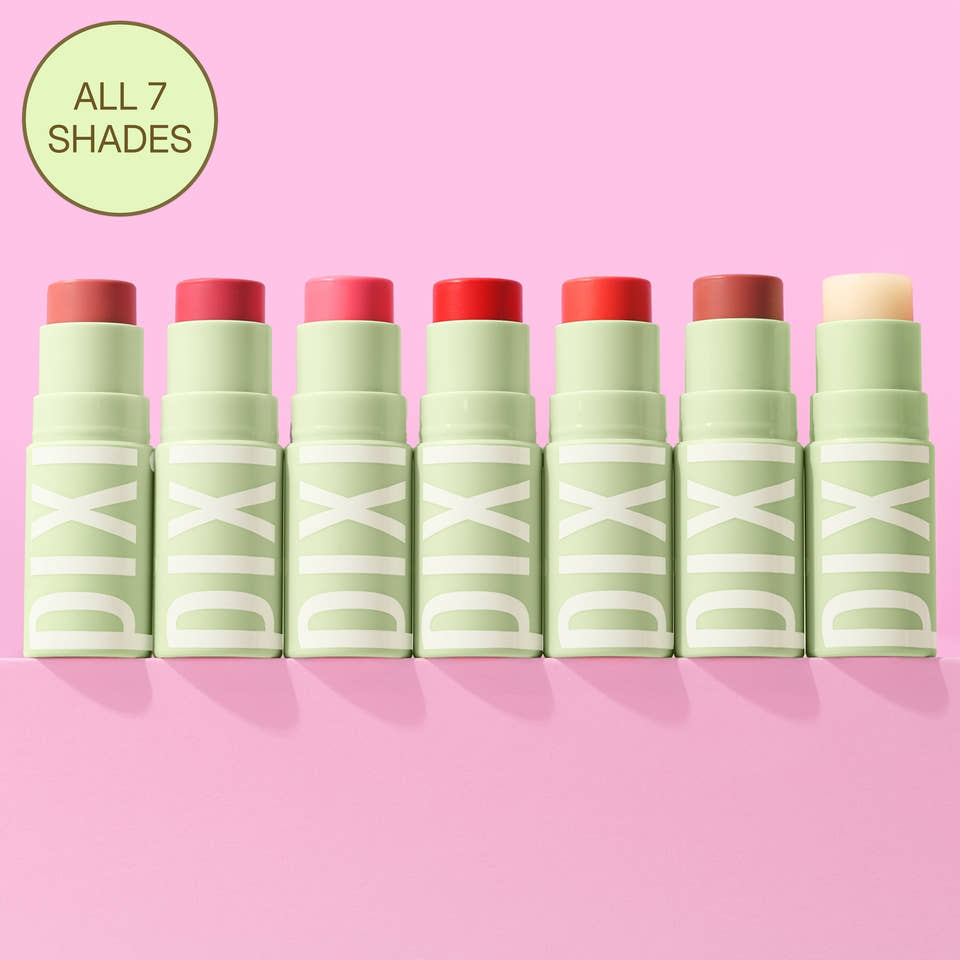 Seven PIXI lip balm tubes in different shades are lined up on a pink background, with a green circular badge in the top left that reads 'ALL 7 SHADES'. view 1