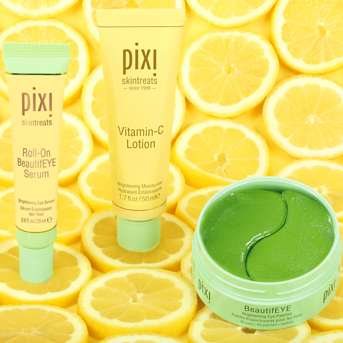 Three Pixi Skintreats BeautifEYE products arranged on a background of sliced lemons: a Roll-On BeautifEYE Serum tube, a Vitamin-C Lotion tube, and an open BeautifEYE jar containing bright green eye patches. The products use yellow and mint-green packaging.