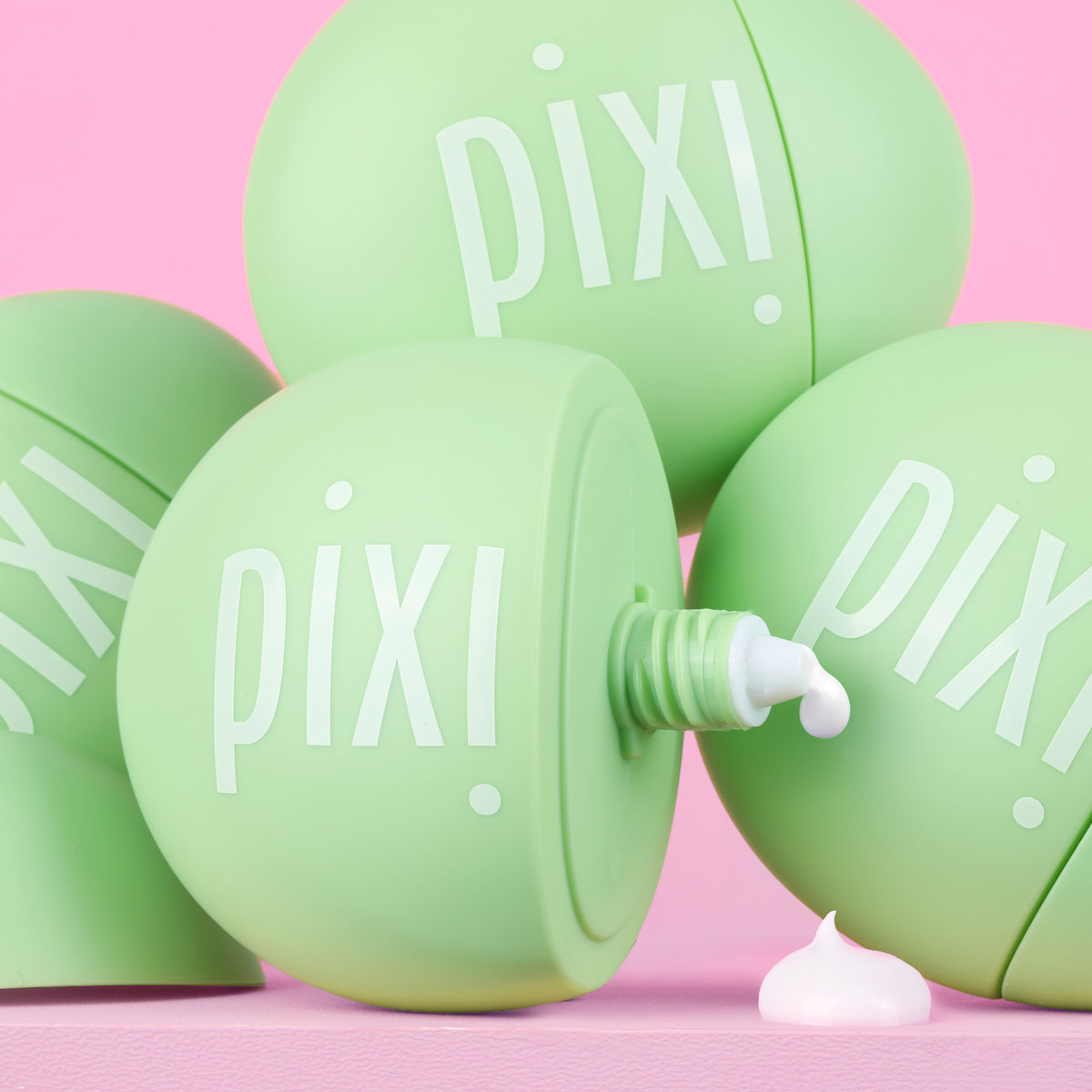 Green PIXI skincare product HandHero showing texture on a pink background