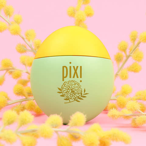 Pixi HandHero PixiMimosa scented hand lotion with mimosa blooms on a pink background