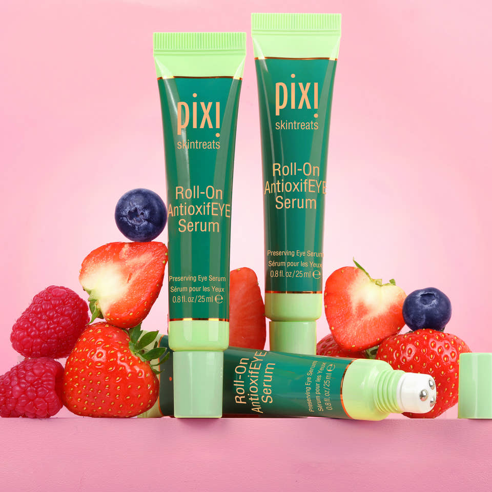 Pixi Roll-On Antioxidant Eye Serum with strawberries and blueberries on a pink background view 1