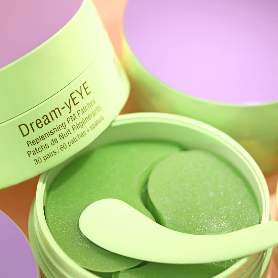 Green container of Dream-yEYE eye patches with an applicator spatula on a colorful background view 1